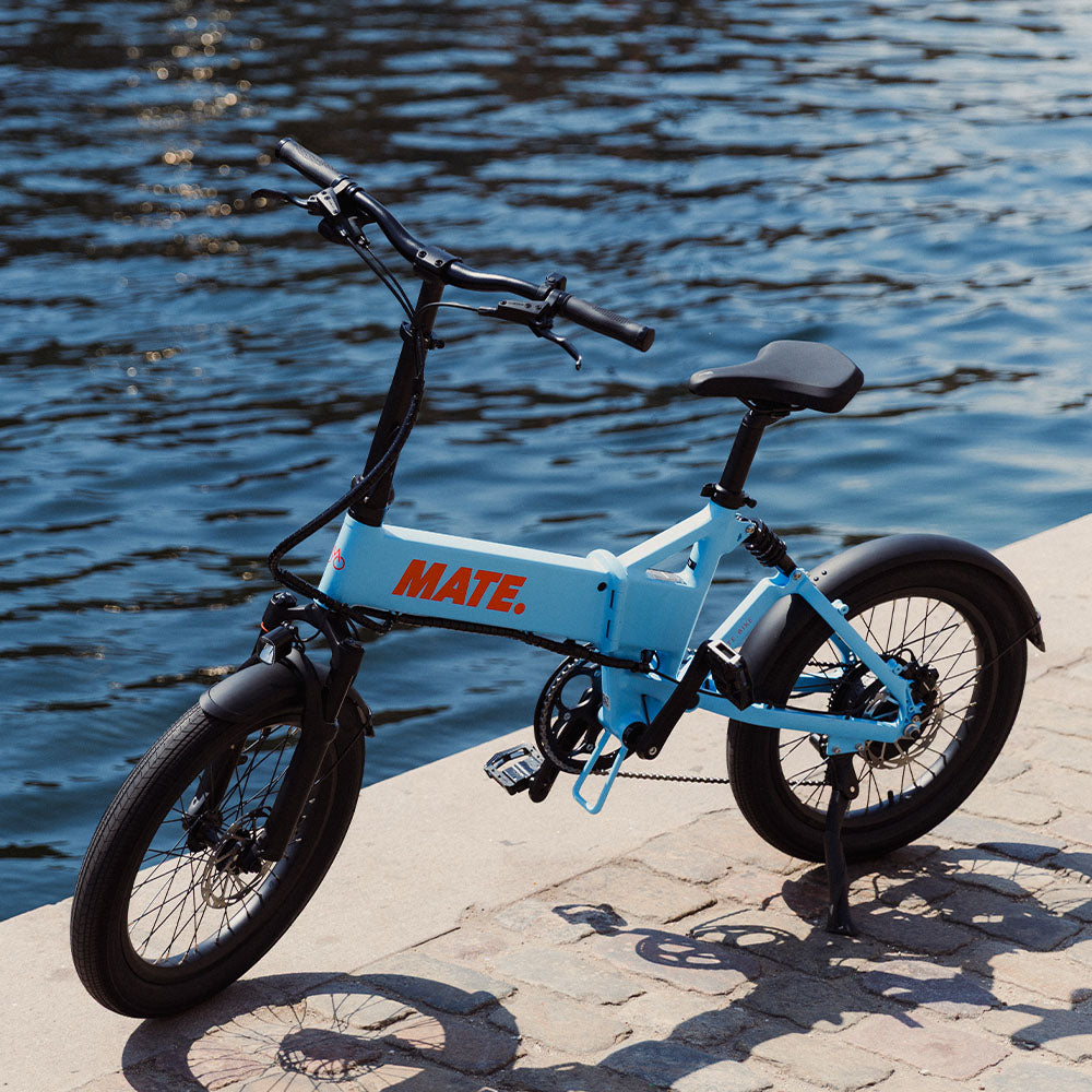 MATE Fusion Folding Electric Bike Lifestyle Static Ocean